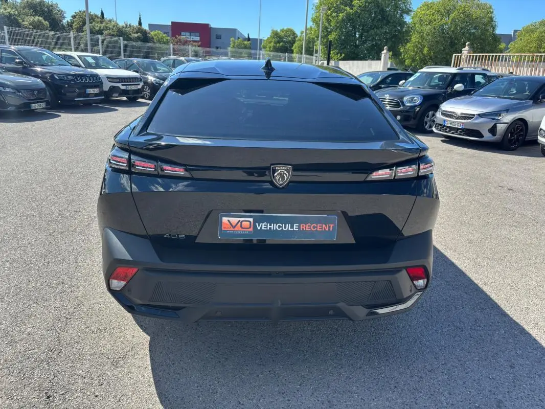 Vue arrière d’une Peugeot 408 noire 2025 avec feux LED distinctifs et jantes alliage 19 pouces, en extérieur.