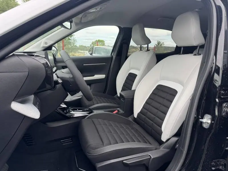 Vue intérieure côté conducteur de la Citroën C3 Aircross 2026, sièges bicolores noir et blanc, tableau de bord moderne.