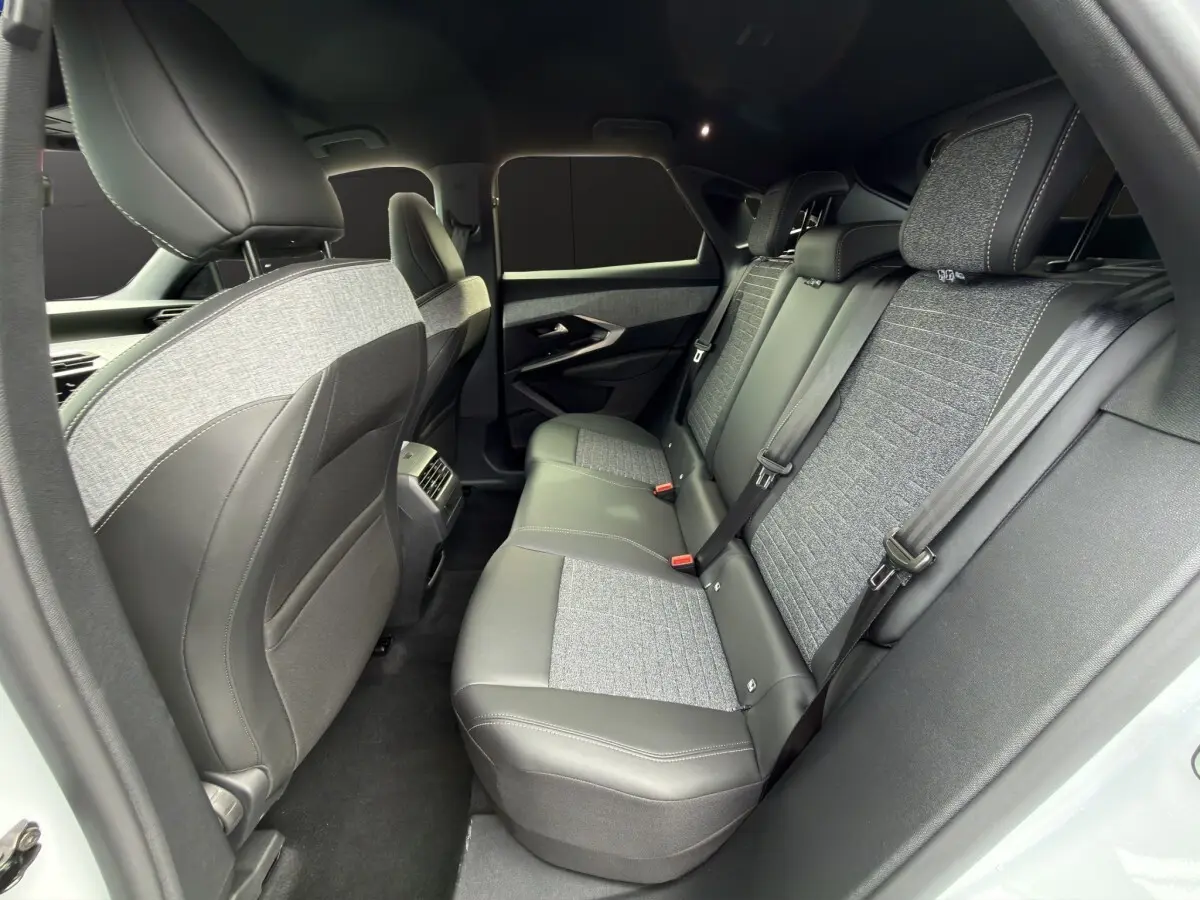 Vue intérieure arrière côté gauche du Peugeot 3008 blanc, sièges en cuir et tissu gris avec ceinture de sécurité.