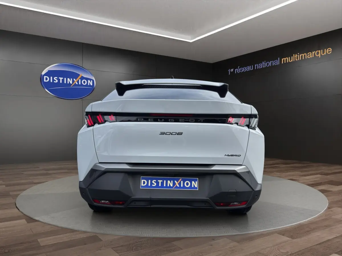 Vue arrière d'un Peugeot 3008 blanc hybride 2025 avec feux LED caractéristiques et logo distinctif au centre.