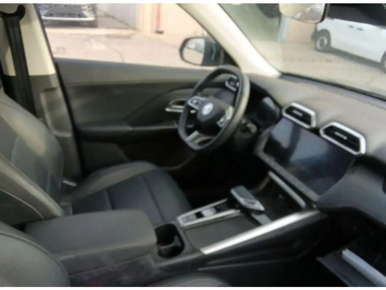Vue intérieure côté conducteur du MG ZS 1.5 Hybrid+ 197 Luxury noir, avec volant cuir et écran tactile central.
