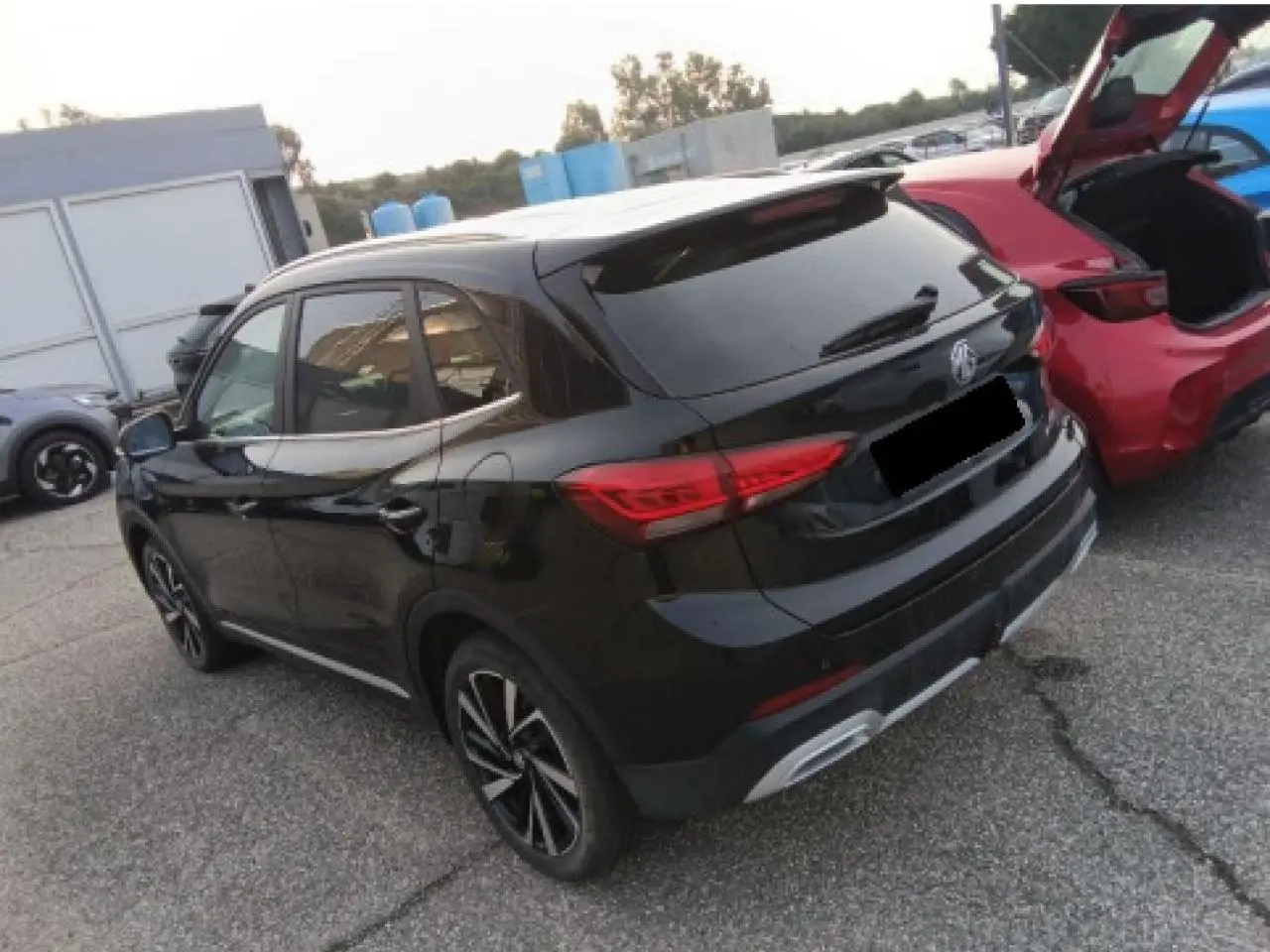 Vue 3/4 arrière droite d’un MG ZS 1.5 Hybrid+ 197 Luxury noir métallisé avec jantes alliage et vitres surteintées.