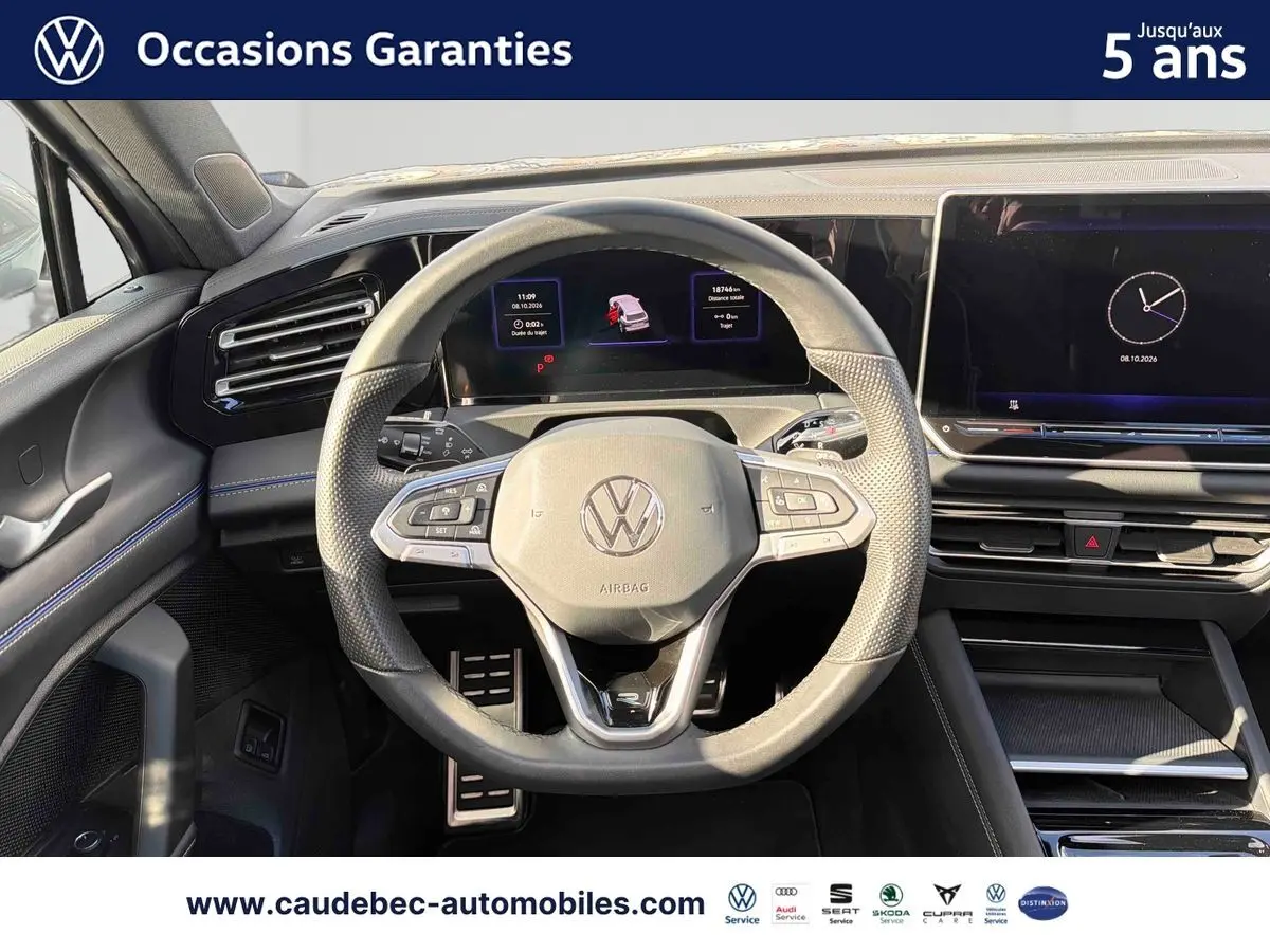 Vue intérieure centrée sur le volant multifonction cuir du Volkswagen Tiguan eHybrid 2025 avec tableau de bord digital.
