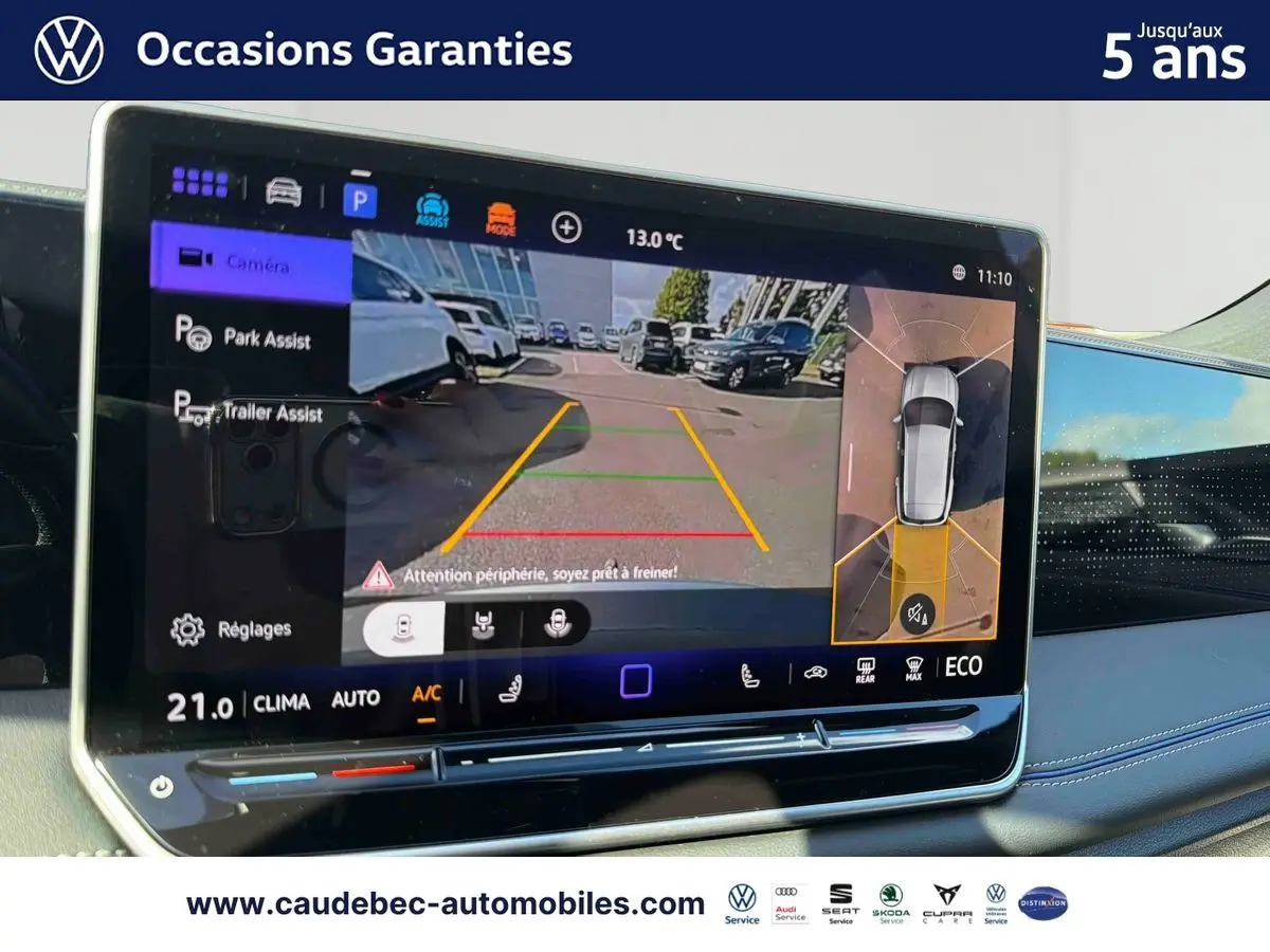 Écran tactile intérieur du Volkswagen Tiguan 2025 montrant l'assistance au stationnement avec vue caméra et vue périmétrique.
