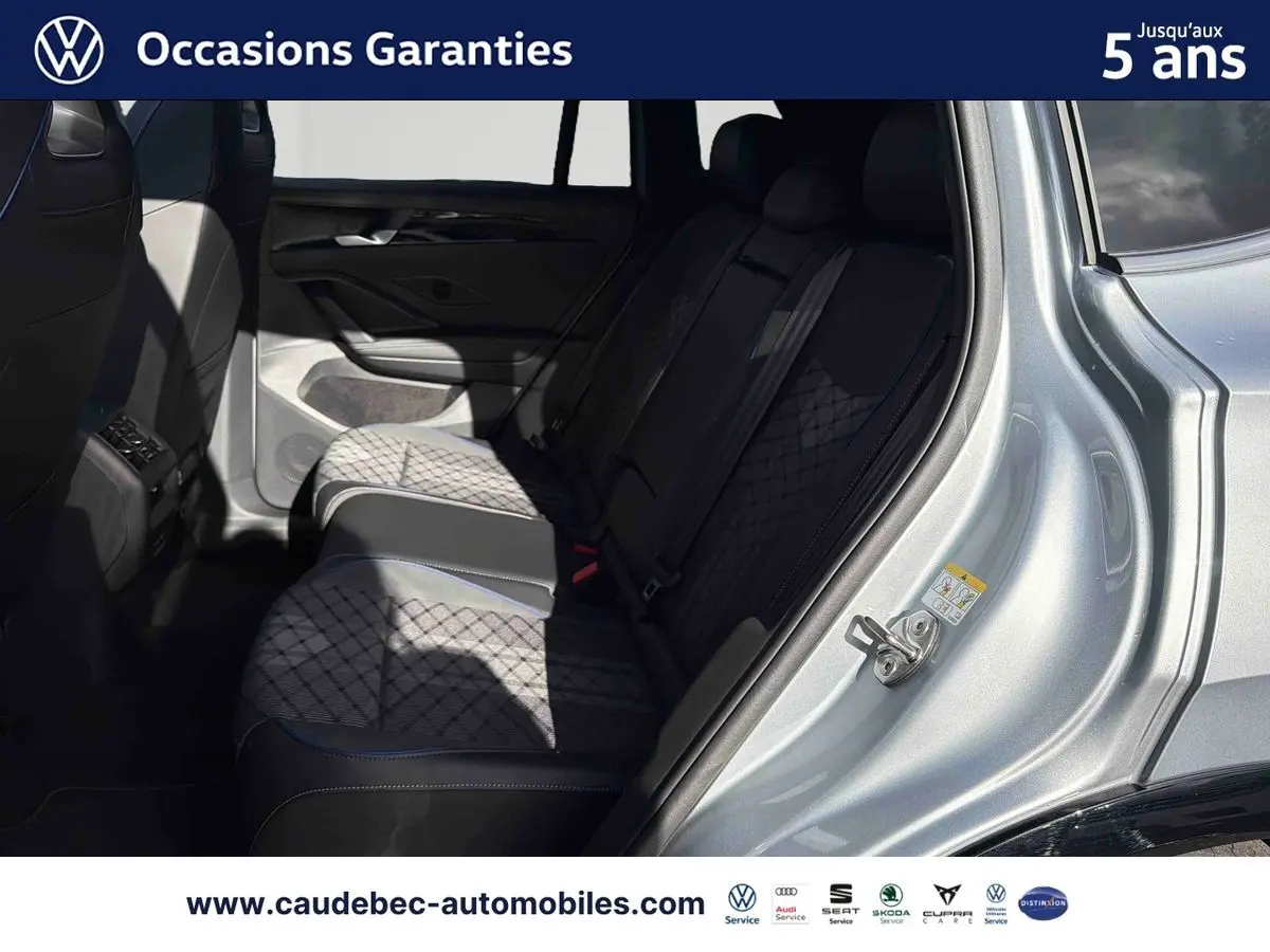 Vue intérieure côté gauche sur les sièges arrière en tissu et cuir du Volkswagen Tiguan argent Dolomite avec porte ouverte.