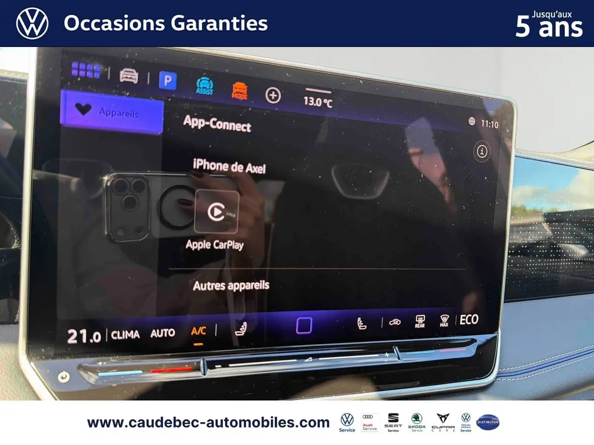 Écran tactile central du Volkswagen Tiguan 1.5 eHybrid 2025 affichant Apple CarPlay, avec tableau de bord bleu visible.