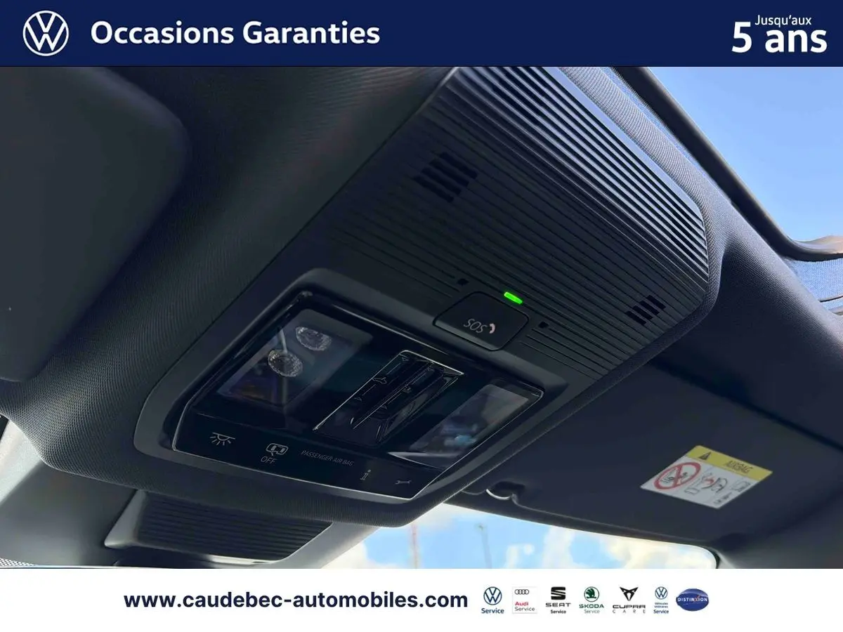 Vue intérieure en contre-plongée du toit ouvrant panoramique et du panneau de commandes de plafonnier noir du Volkswagen Tiguan argent Dolomite.