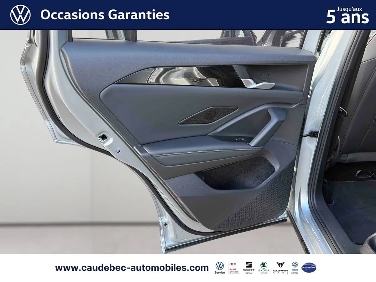 Porte arrière gauche ouverte d’un Volkswagen Tiguan 1.5 eHybrid 2025 couleur argent Dolomite, intérieur noir et garnitures modernes.