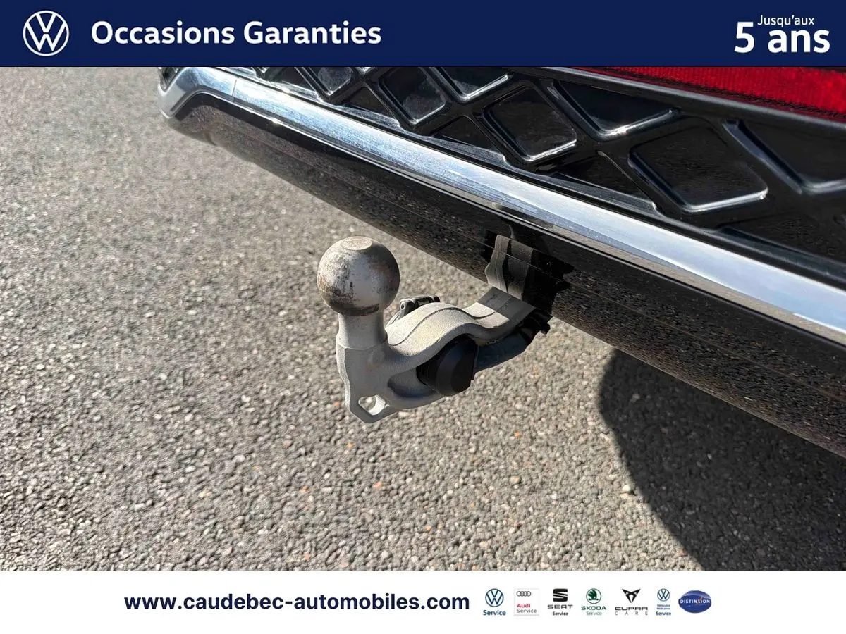 Gros plan sur le crochet d'attelage escamotable à l'arrière d'un Volkswagen Tiguan argent Dolomite.