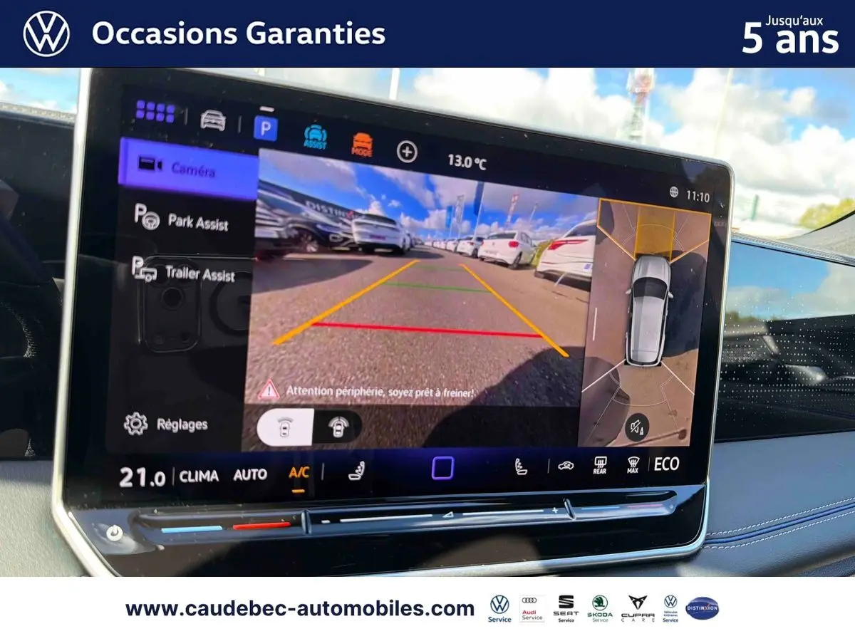 Écran tactile intérieur affichant la caméra de recul et l'assistance au stationnement du Volkswagen Tiguan eHybrid argent.