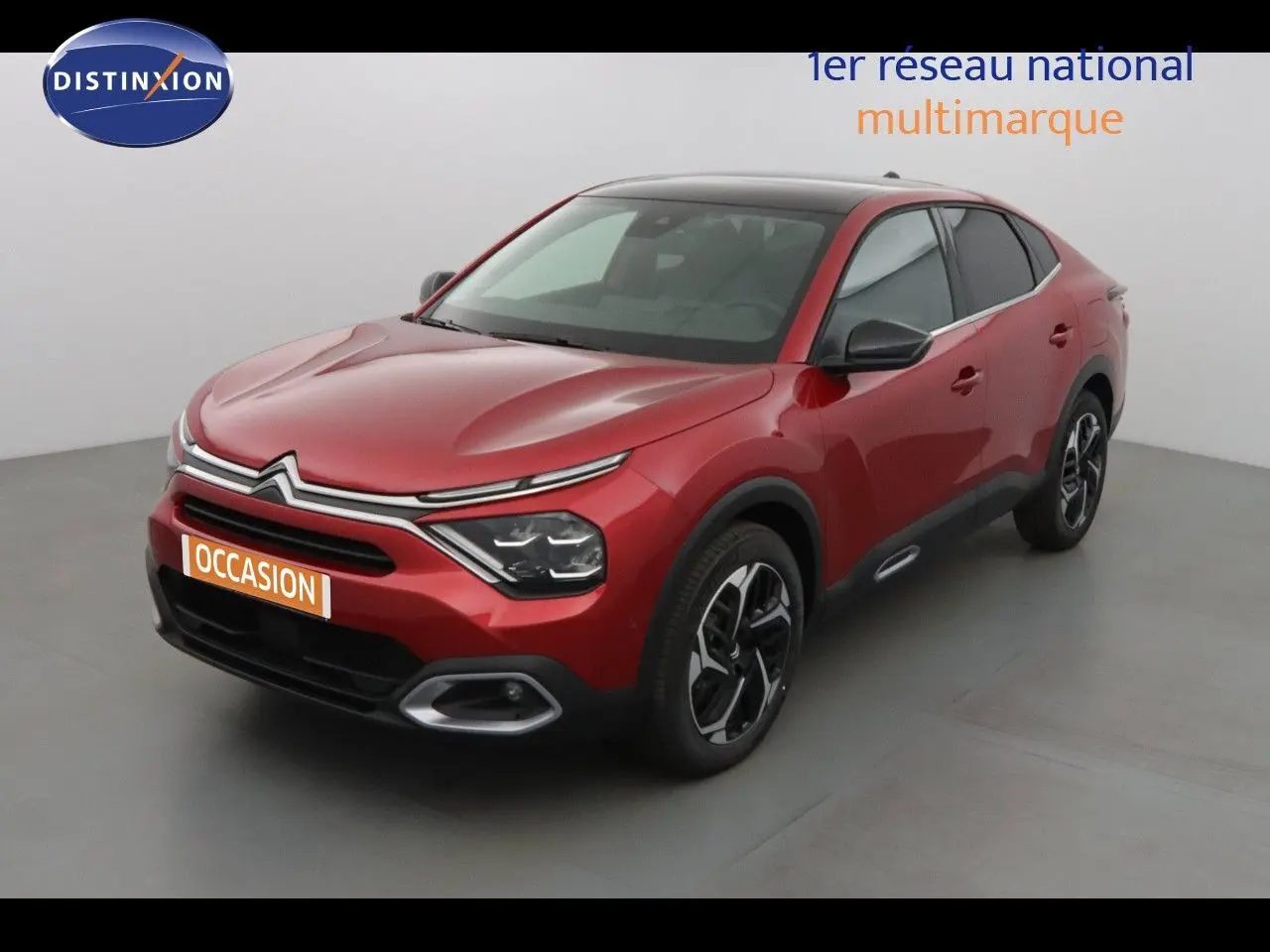 Citroën C4 X rouge Elixir métal en 3/4 avant droit, avec calandre distinctive et jantes bicolores.