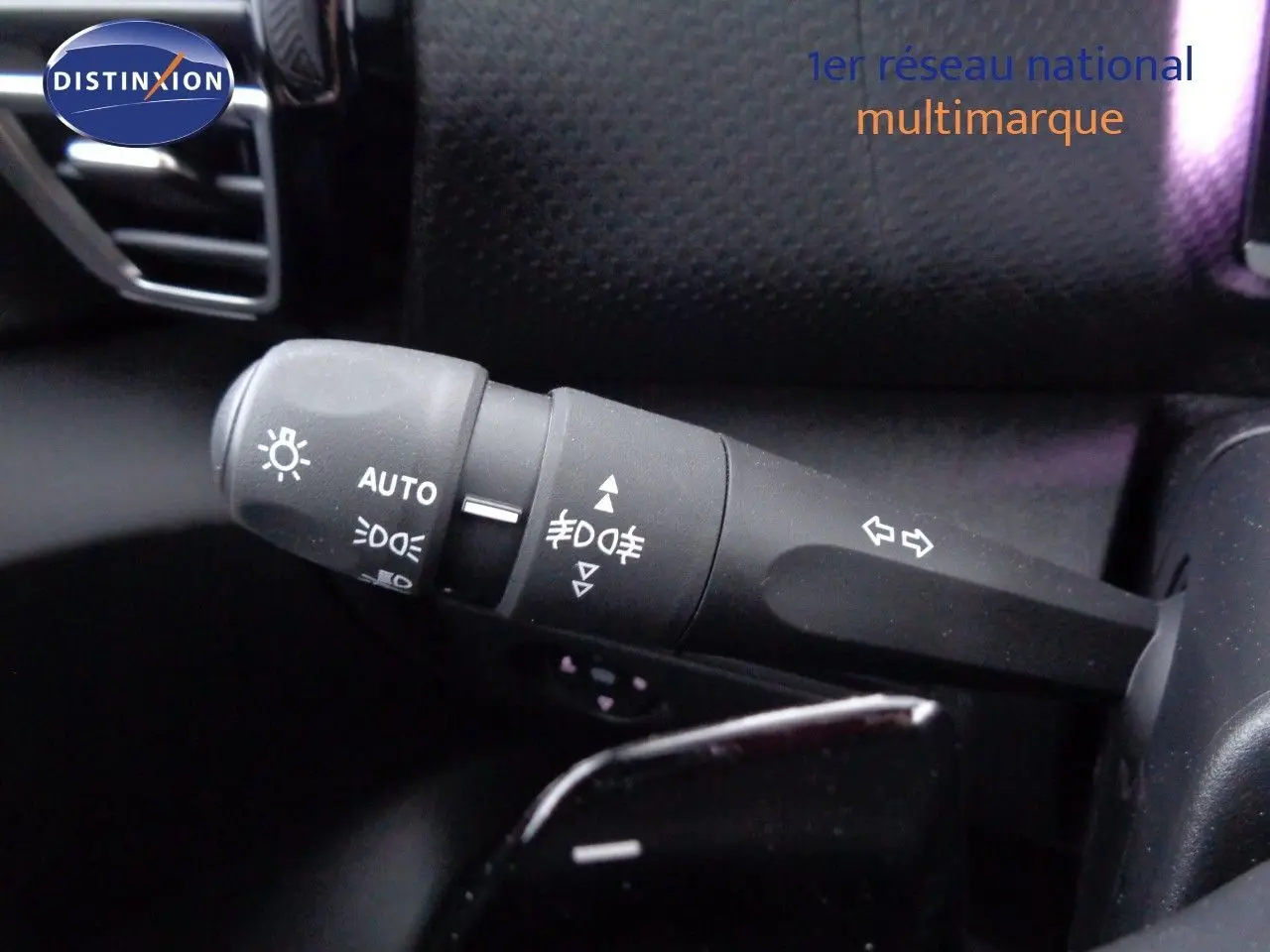 Gros plan sur la commande des feux et clignotants dans l’habitacle d’une Citroën C4 X rouge Elixir Metal.