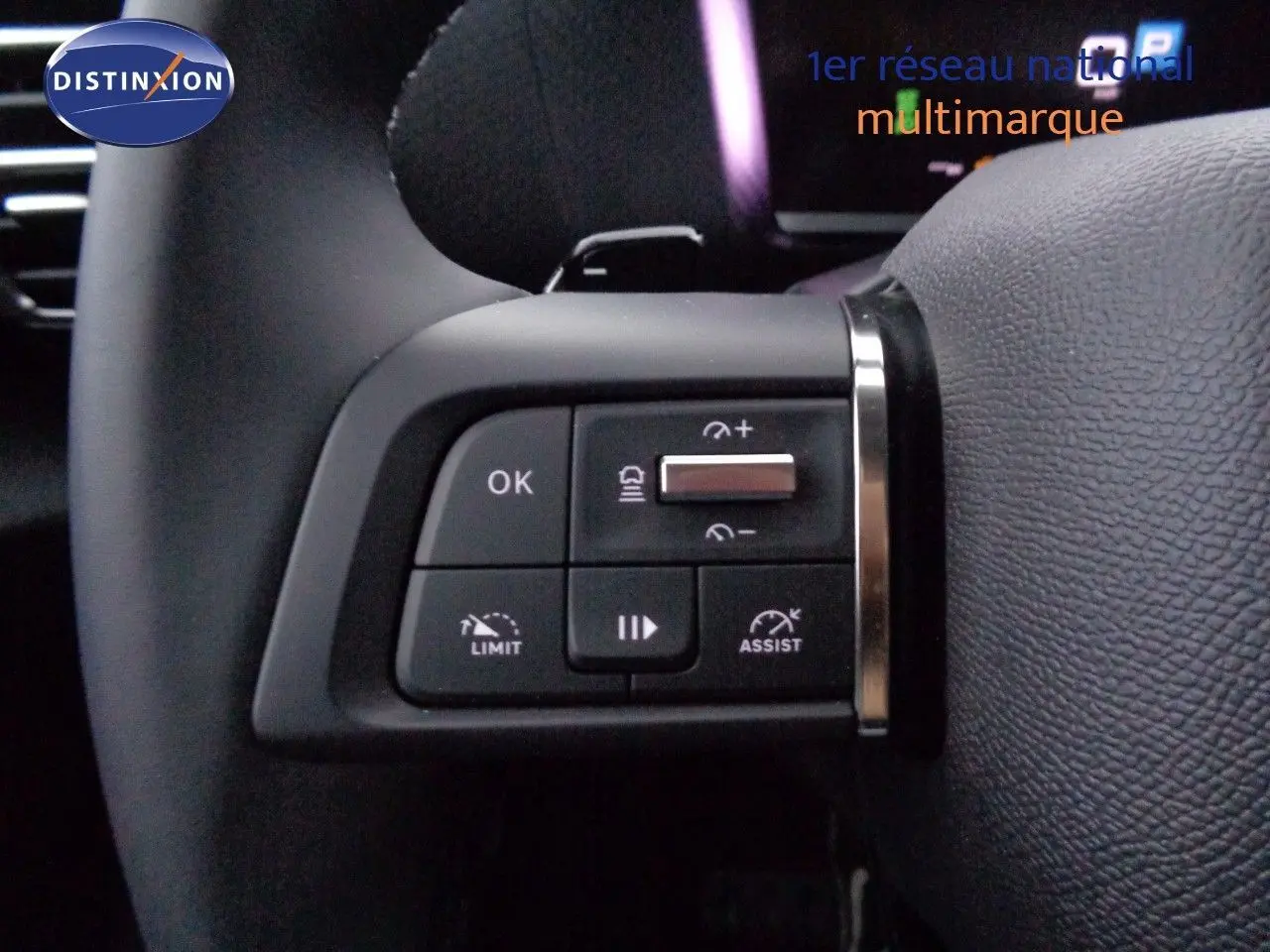 Gros plan sur les commandes au volant côté gauche du Citroën C4 X rouge Elixir Metal, mettant en valeur les boutons de régulateur et limiteur.