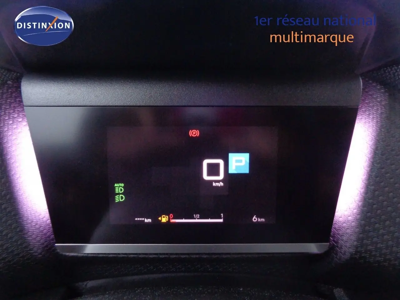 Tableau de bord numérique de la Citroën C4 X 2023 affichant la vitesse à 0 km/h et le mode parking, éclairage violet ambiant.