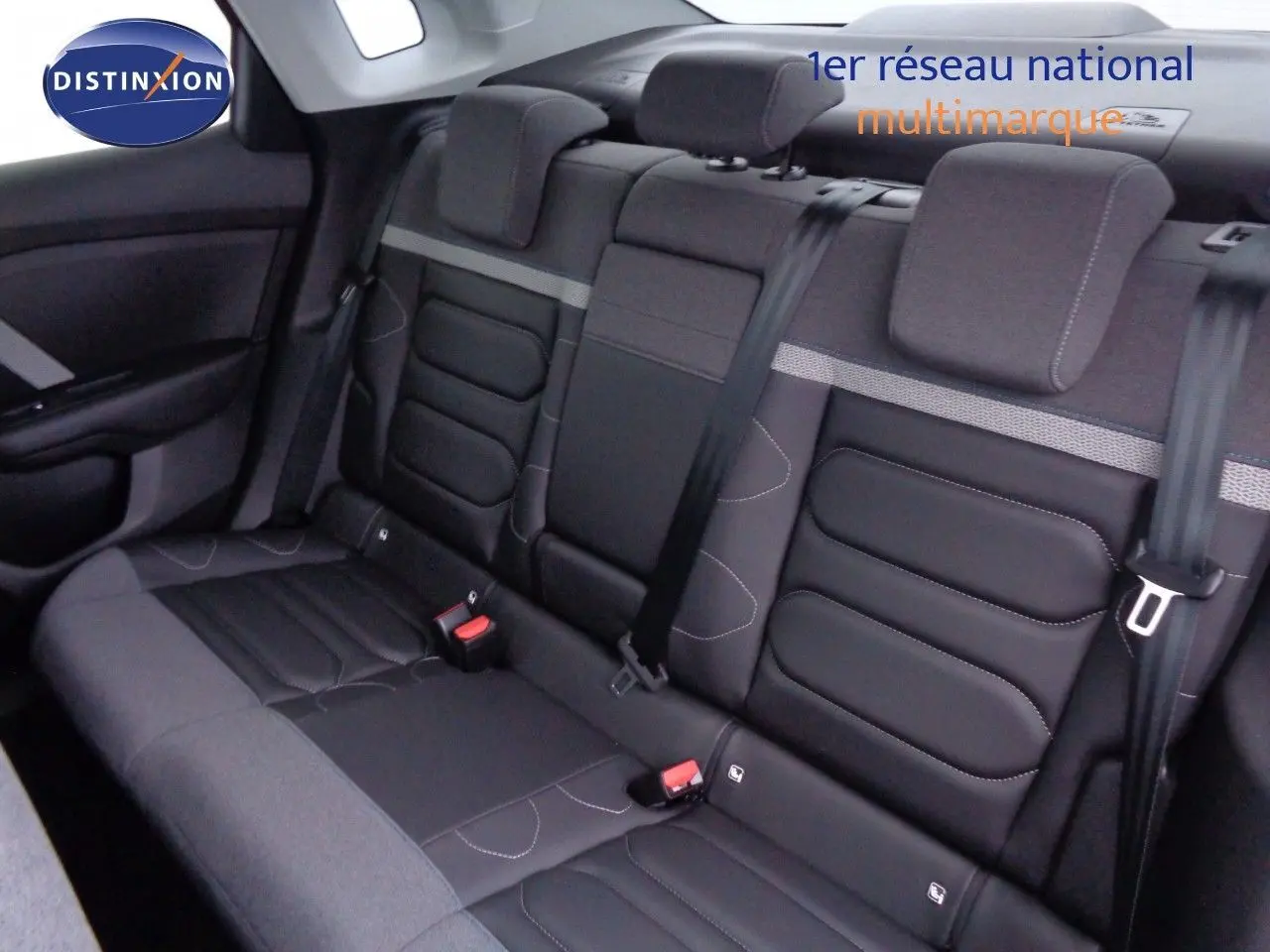 Vue intérieure sur la banquette arrière en tissu et cuir noir du Citroën C4 X 2023, avec ceintures de sécurité visibles.