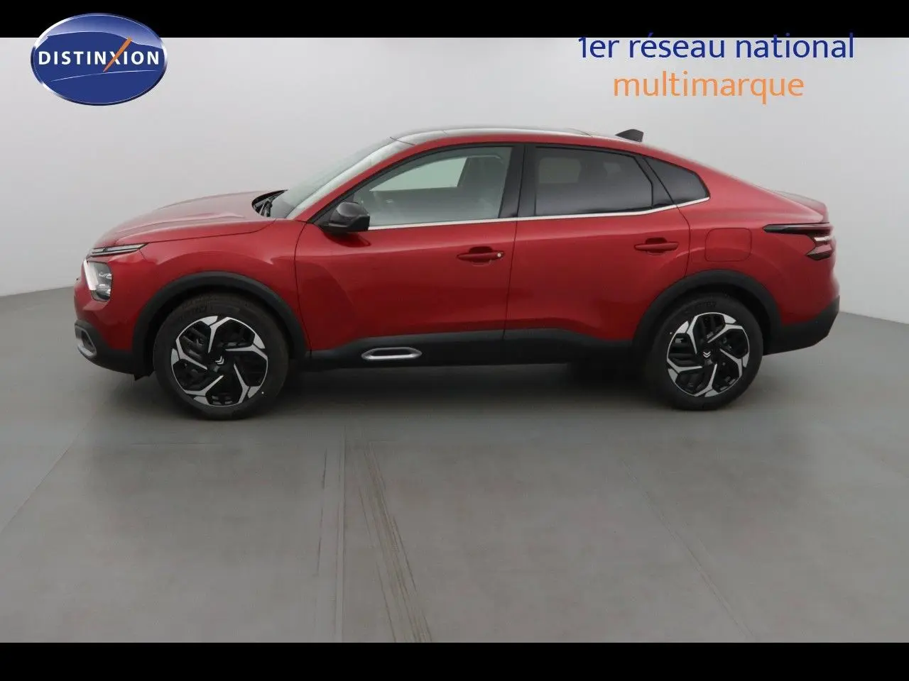 Vue latérale droite d'une Citroën C4 X rouge Elixir métal 2023 avec jantes noires et détails noirs contrastants.