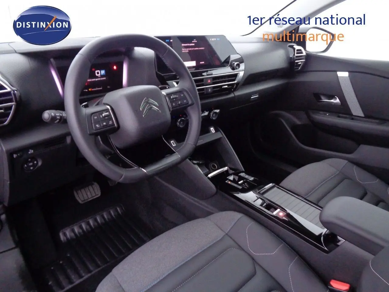 Vue intérieure du poste de conduite de la Citroën C4 X 2023, avec volant multifonction et finition noire moderne.