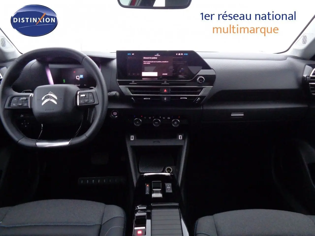 Vue intérieure frontale du tableau de bord et volant du Citroën C4 X 2023, finition noire avec écran tactile central.
