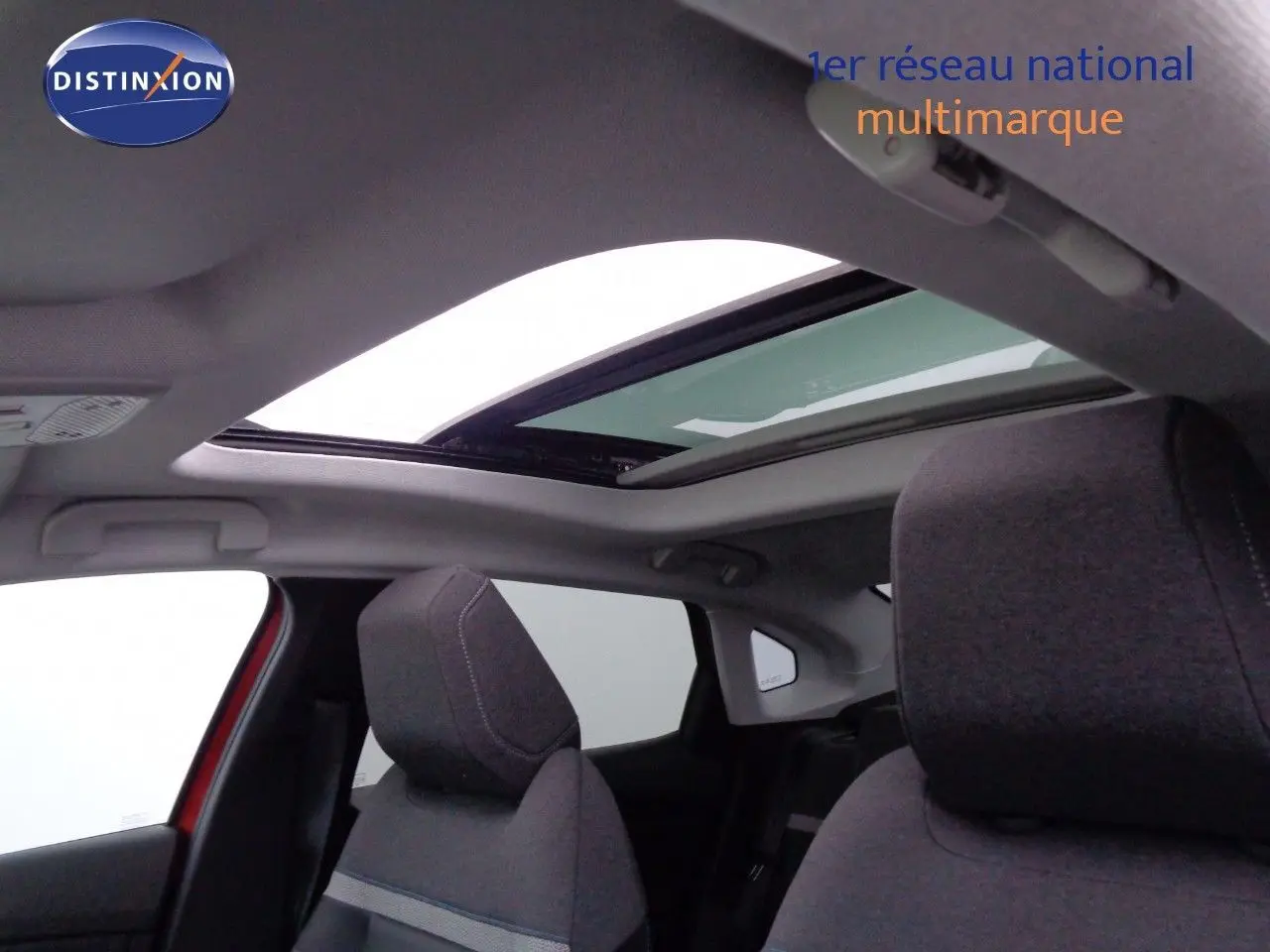 Vue intérieure du toit ouvrant panoramique et des sièges avant gris du Citroën C4 X rouge Elixir Metal.