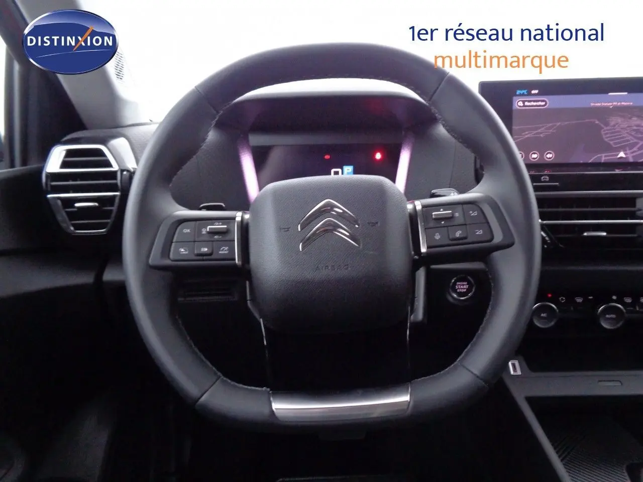 Vue rapprochée du volant noir de la Citroën C4 X 2023 avec commandes intégrées et tableau de bord digital.