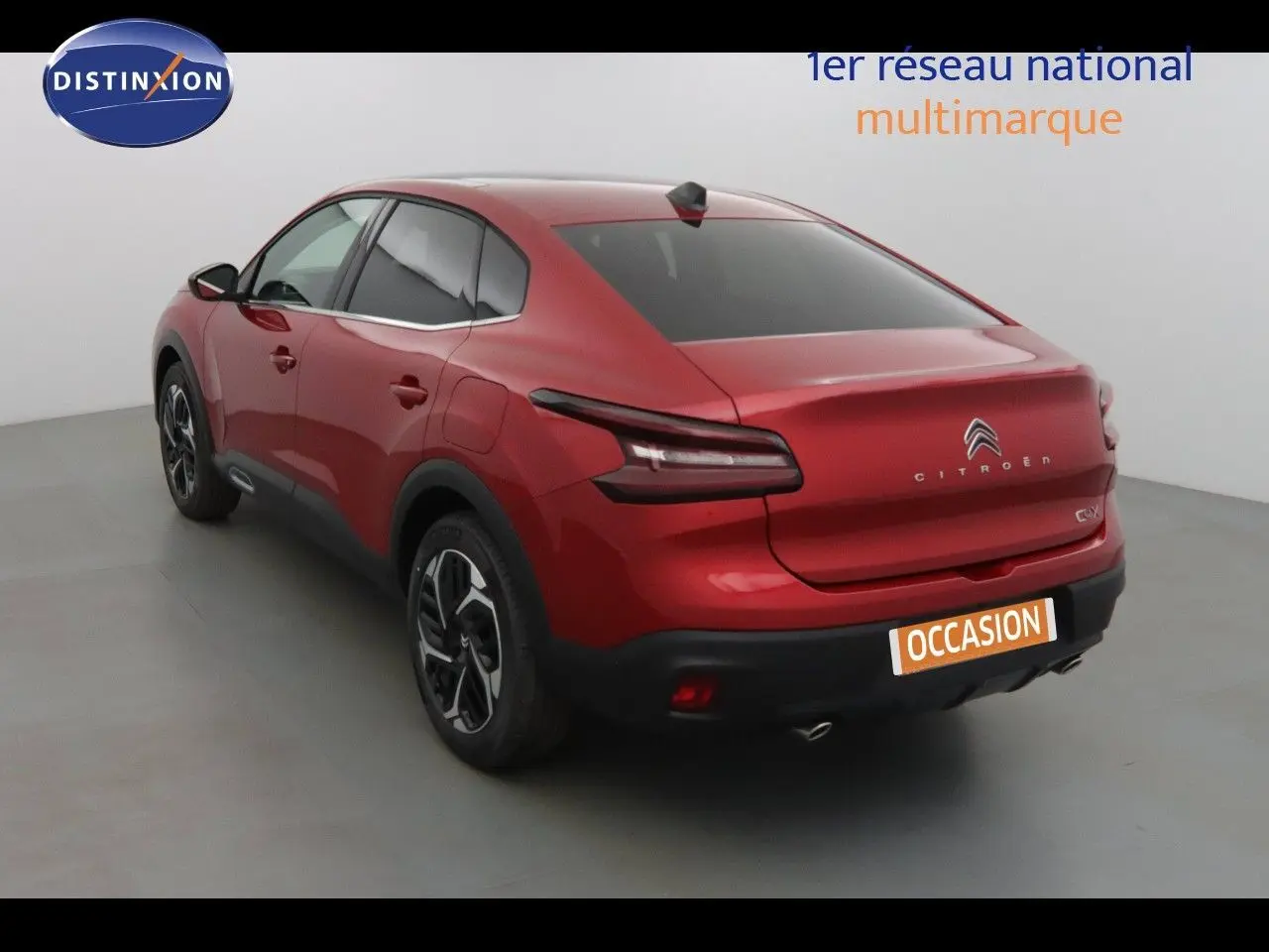 Vue 3/4 arrière droite d'une Citroën C4 X rouge Elixir métal avec feux arrière LED et jantes bi-ton.