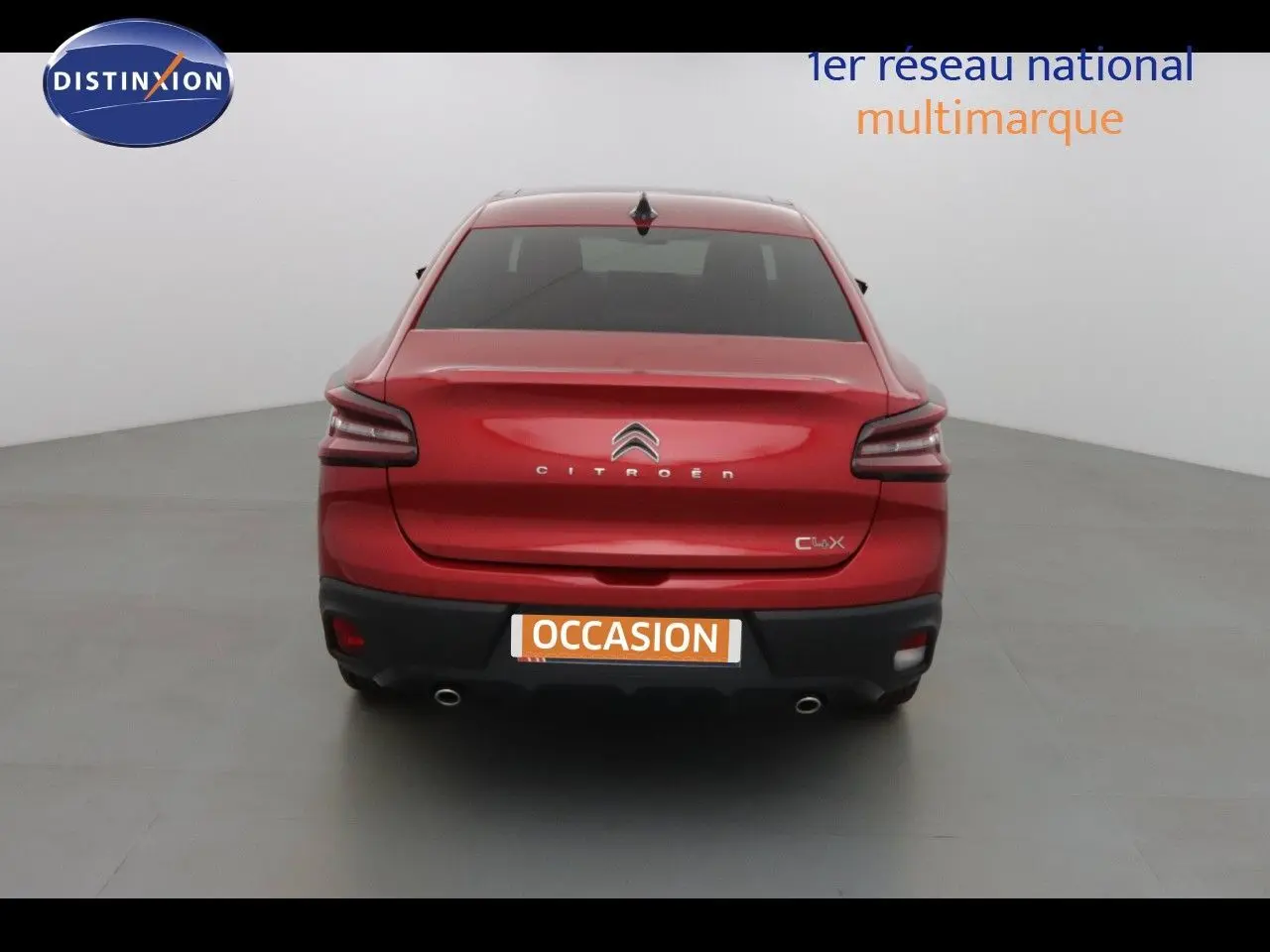 Vue arrière d'une Citroën C4 X rouge Elixir métal avec feux LED et double sortie d'échappement visible.