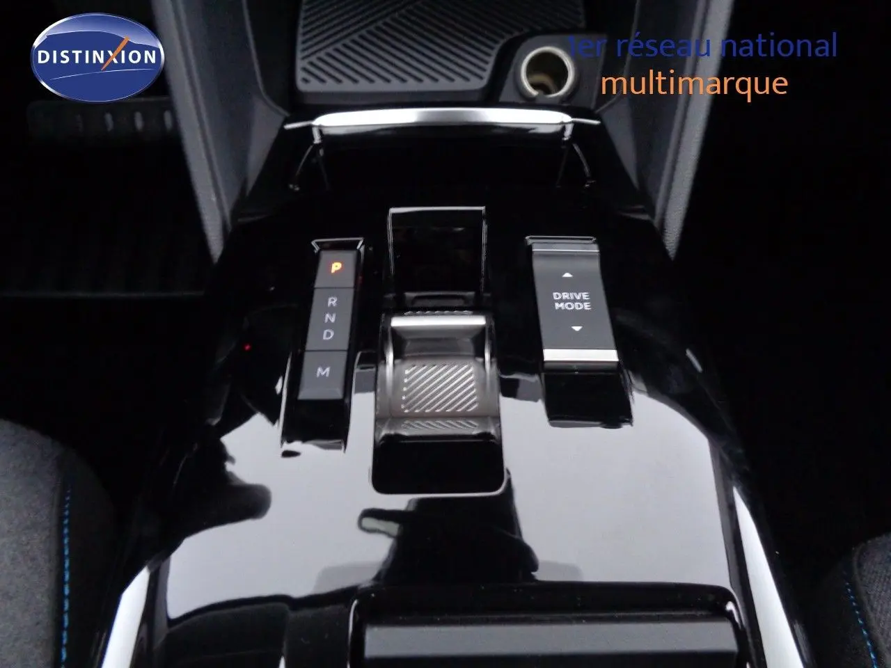 Gros plan sur la console centrale noire brillante du Citroën C4 X, avec levier de vitesses automatique et bouton Drive Mode.