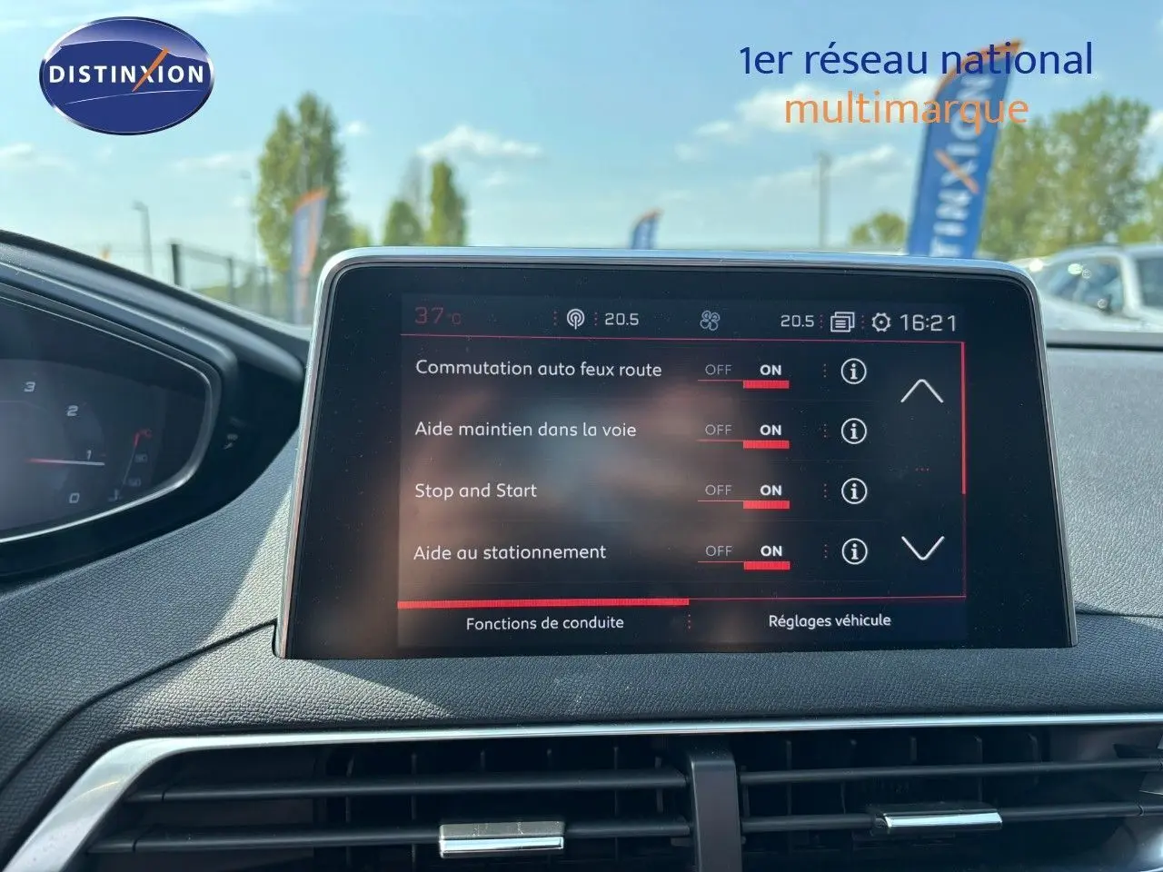 Écran tactile central du tableau de bord du Peugeot 3008 blanc nacré, affichant les aides à la conduite activées.