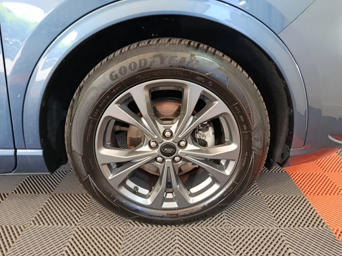 Gros plan sur la roue avant gauche du Ford Kuga bleu 2024 avec jante alliage et pneu Goodyear visible.