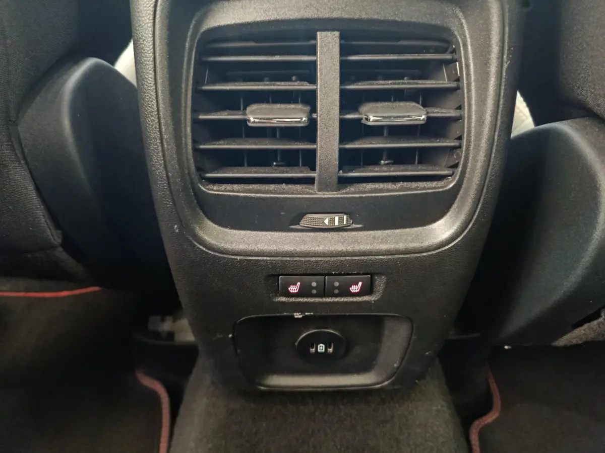 Vue rapprochée de la console arrière noire du Ford Kuga 2024 avec aérateurs et commandes chauffantes des sièges arrière.