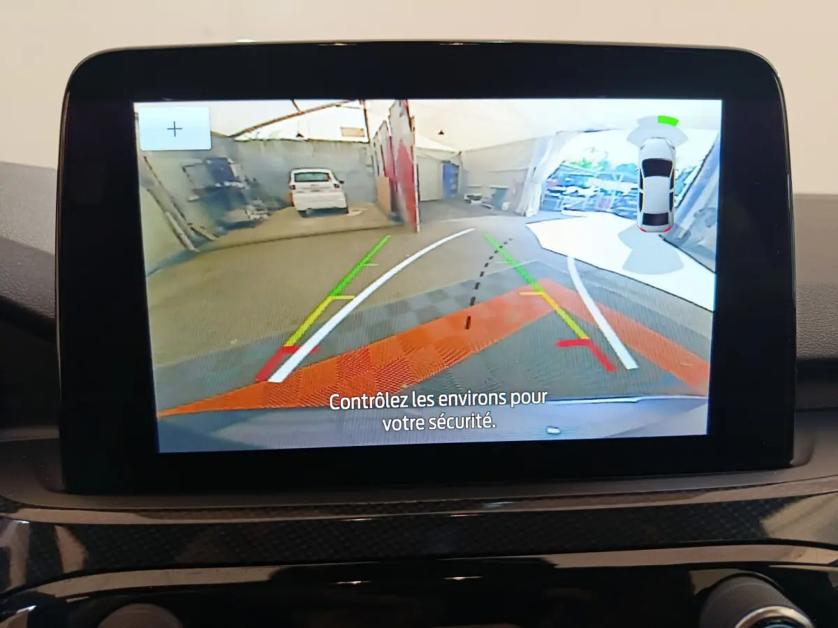 Écran tactile intérieur montrant la caméra de recul avec guidage et vue 360° du Ford Kuga bleu 2024.