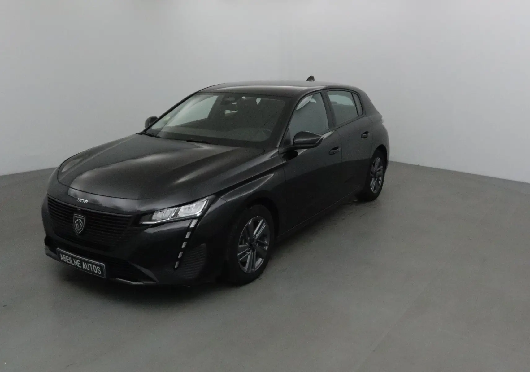 PEUGEOT 308 noir vue 3/4 arrière droit, avec feux arrière LED distinctifs et jantes alliage 16 pouces.