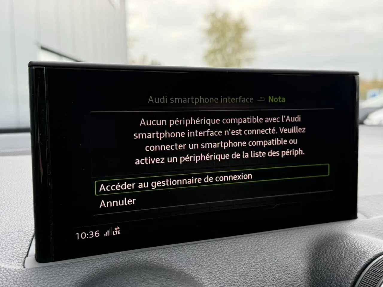 Écran central de l'Audi Q2 35 TFSI S-Line 2023 affichant le message de connexion smartphone, intérieur gris.
