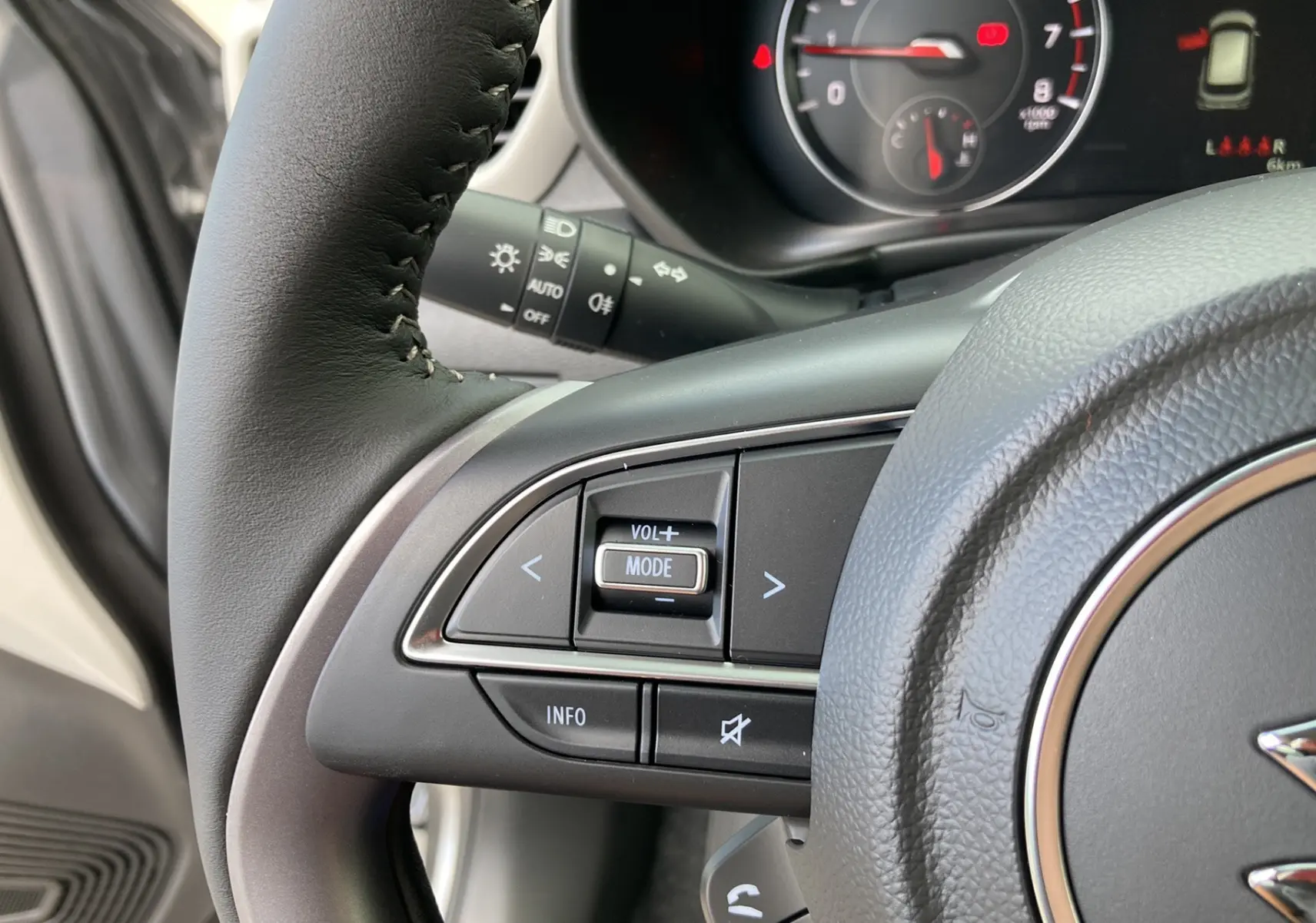 Gros plan sur le volant cuir multifonctions côté gauche de la Suzuki Swift 2025 couleur Premium silver metal.