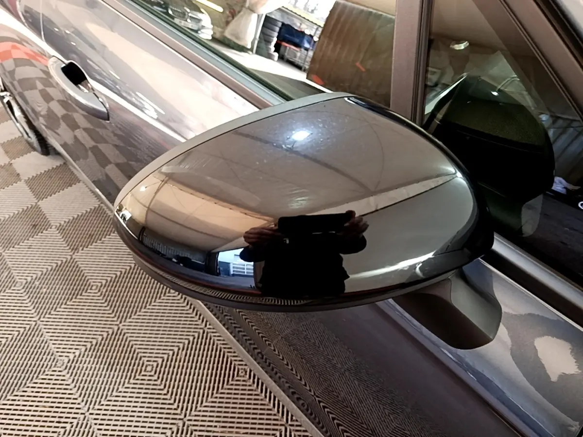 Rétroviseur côté gauche gris foncé de Renault Clio Evolution SCe 65 2022, vue rapprochée avec reflet du plafond.