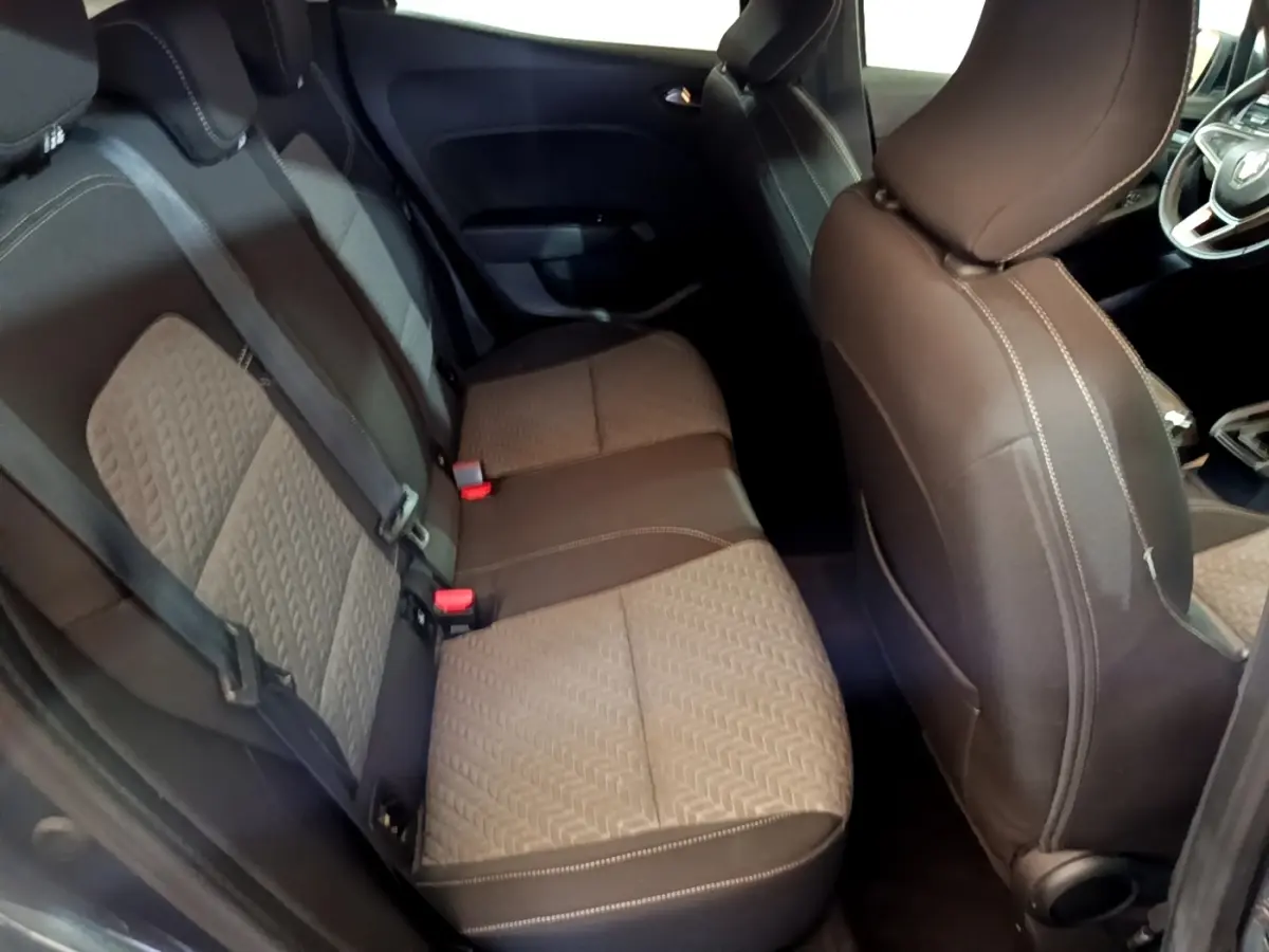 Vue intérieure côté droit montrant la banquette arrière et le siège avant de la Renault Clio gris foncé Evolution SCe 65 2022.