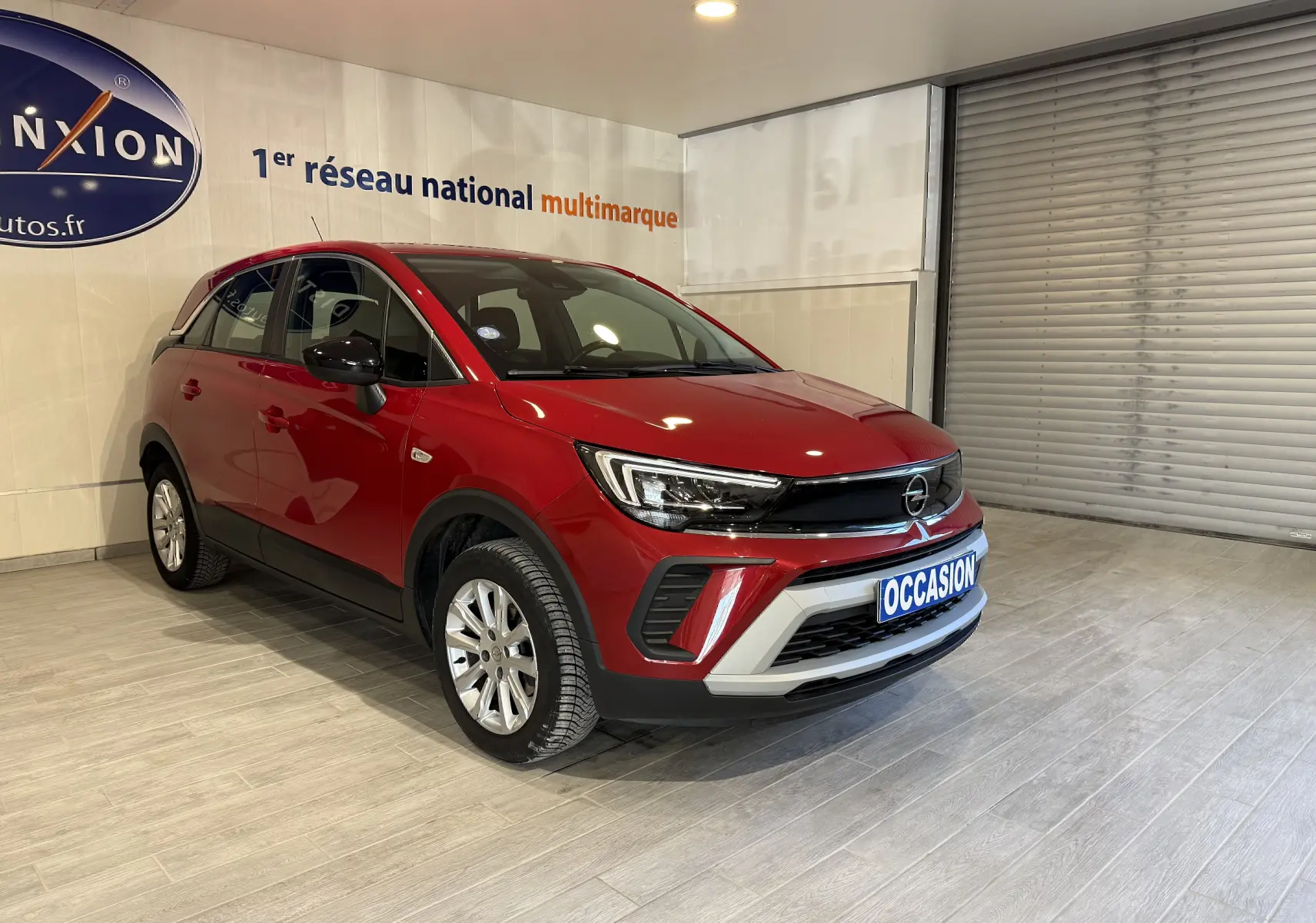 Opel Crossland rouge 2022 en 3/4 avant droit, avec calandre noire et plaque "OCCASION" visible.