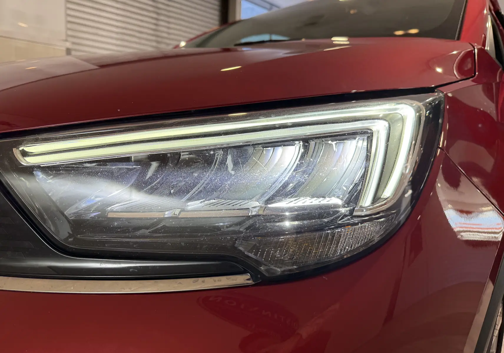 Gros plan sur le phare avant droit rouge de l’Opel Crossland 2022, mettant en valeur son design LED distinctif.