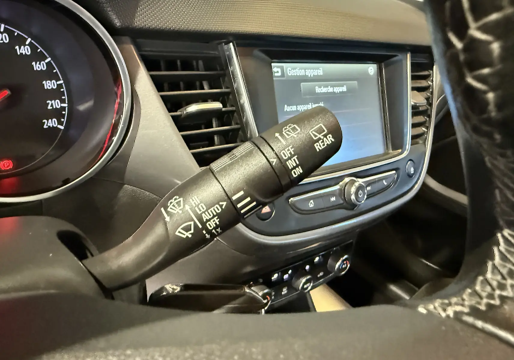 Vue rapprochée du commodo d’essuie-glace et du tableau de bord noir de l’Opel Crossland 2022.