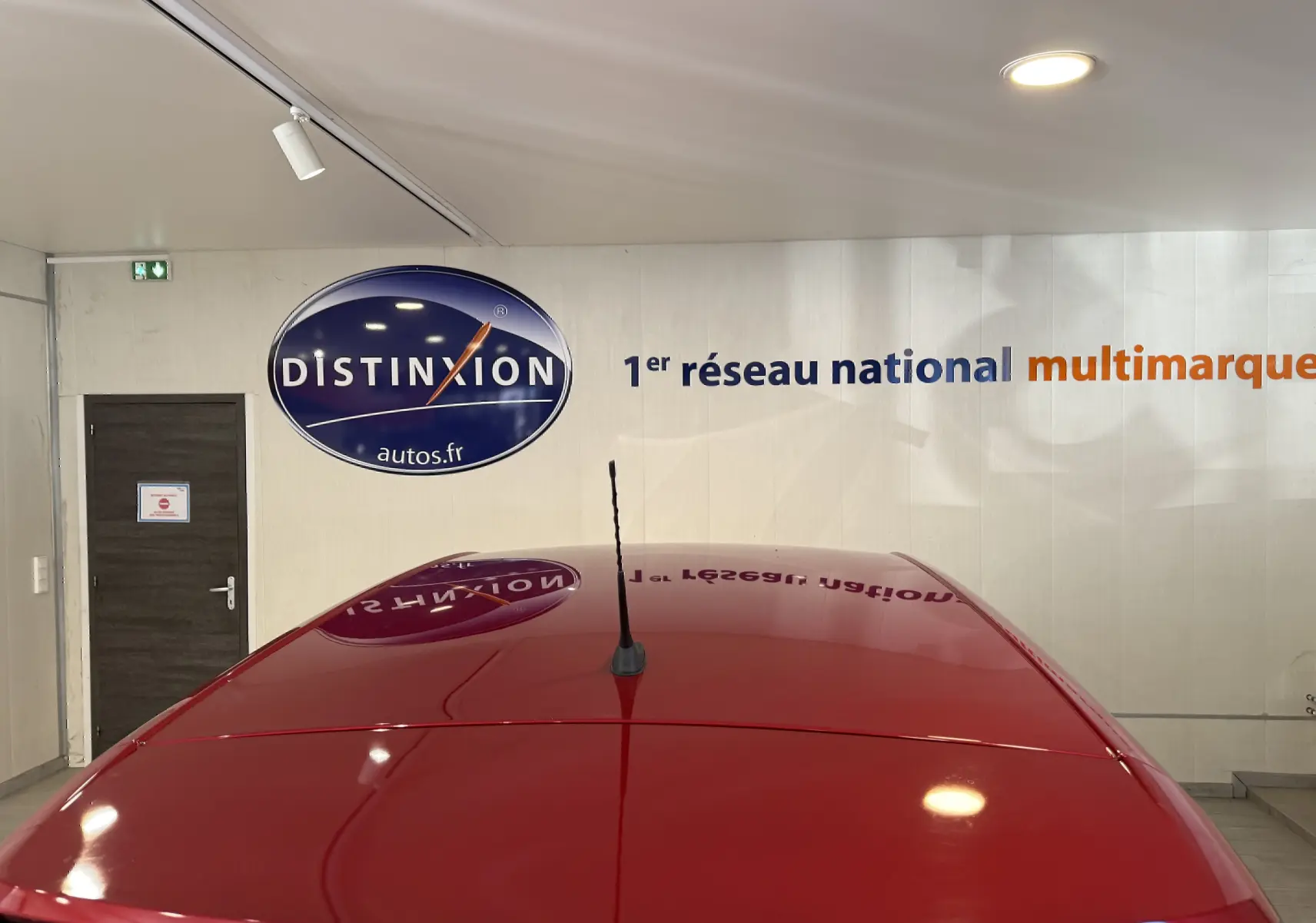 Toit rouge brillant de l'Opel Crossland 2022 vu de dessus avec antenne centrale dans un showroom.