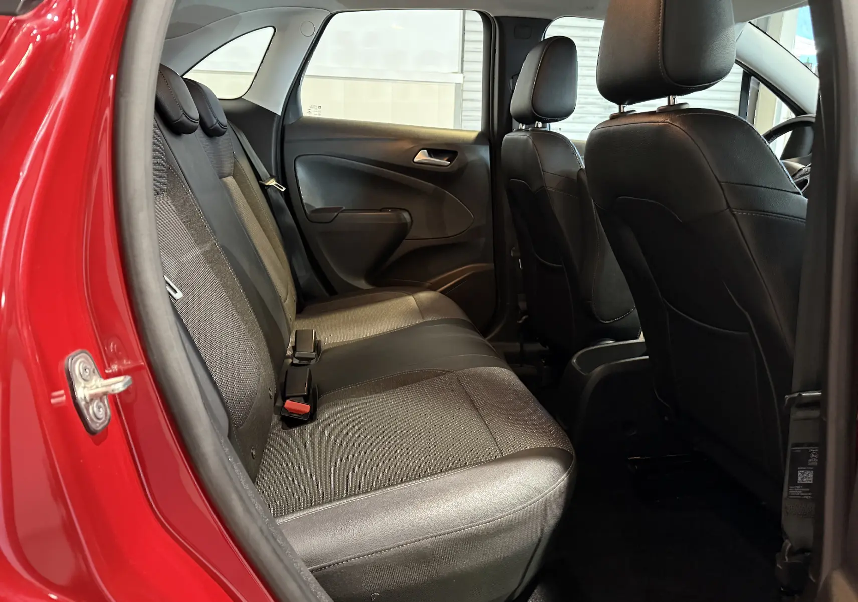 Vue intérieure côté gauche sur les sièges arrière noirs et gris d’un Opel Crossland rouge 2022.