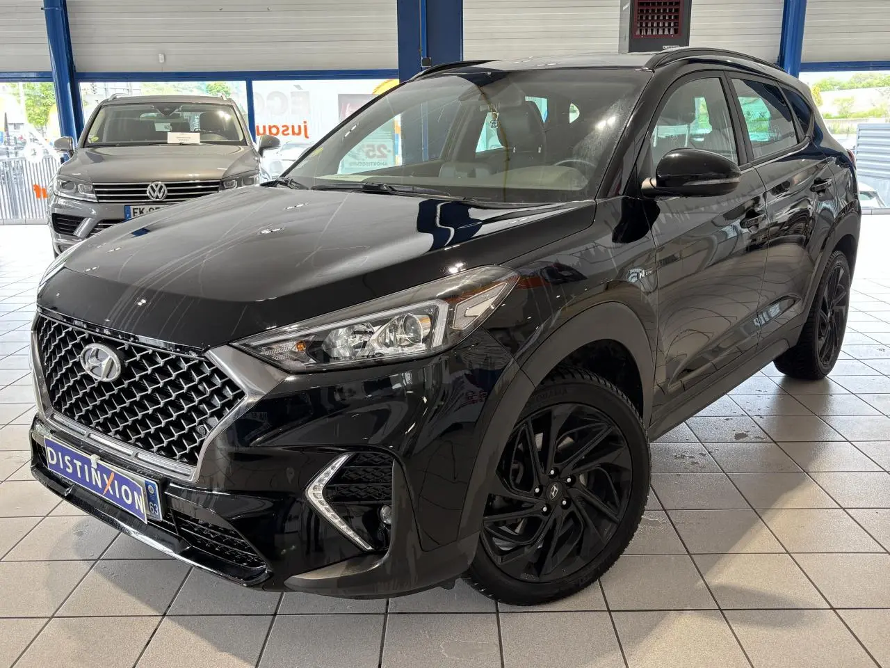 Hyundai Tucson noir en 3/4 avant droit, avec calandre N Line chromée et jantes alliage noires 19 pouces.