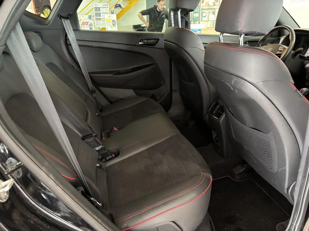 Vue intérieure côté gauche des sièges arrière noirs avec surpiqûres rouges du Hyundai Tucson N Line Edition 2020.