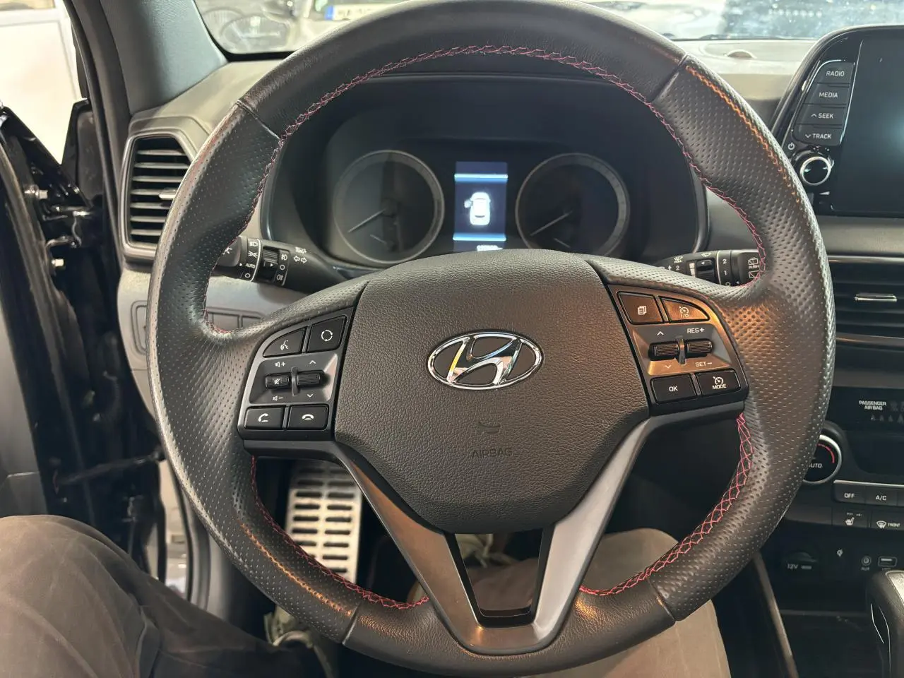 Vue intérieure centrée sur le volant cuir noir avec surpiqûres rouges du Hyundai Tucson N Line 2020.