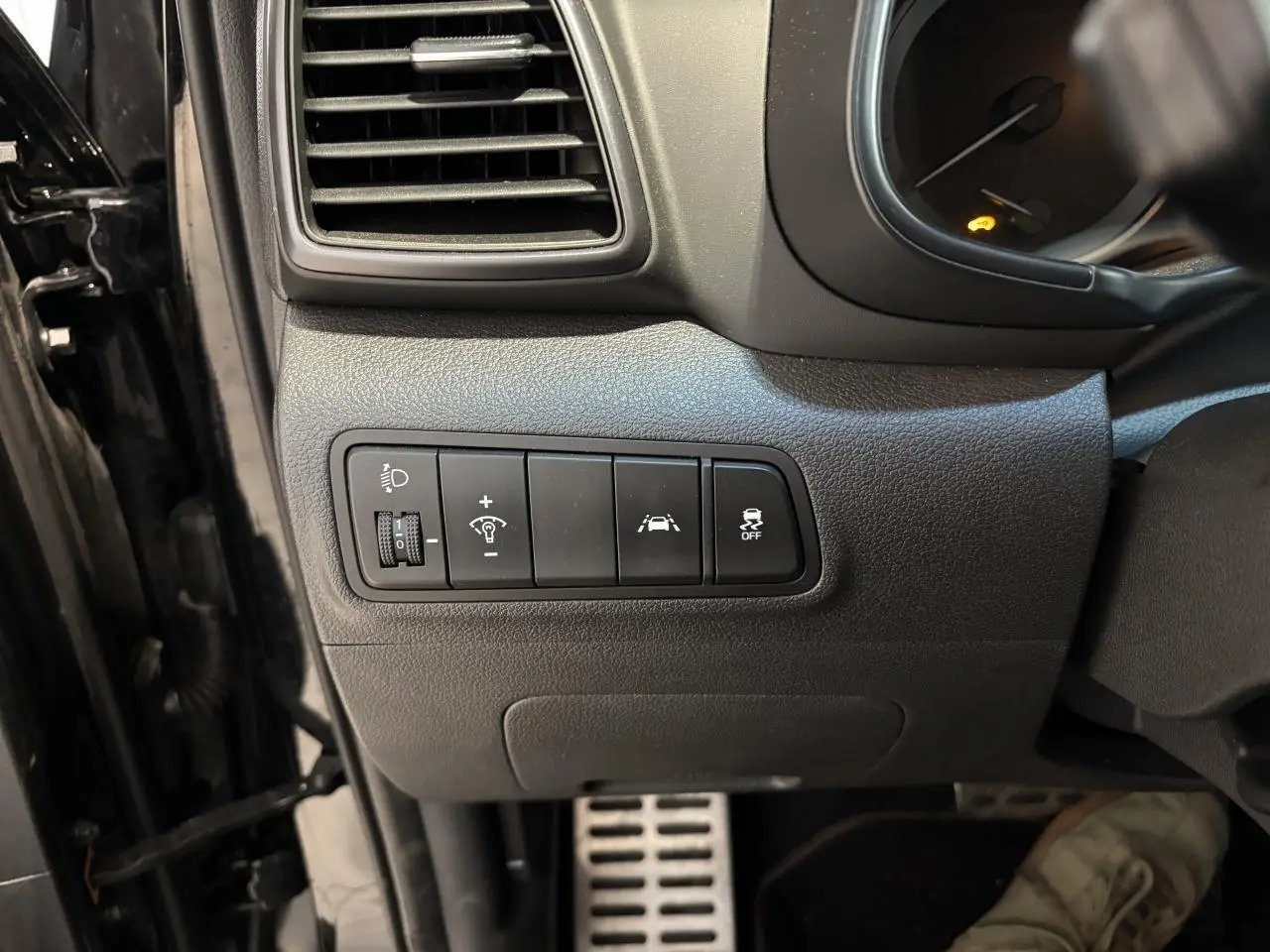 Vue intérieure côté gauche du tableau de bord noir du Hyundai Tucson 2020 avec commandes d'assistance et pédalier aluminium.