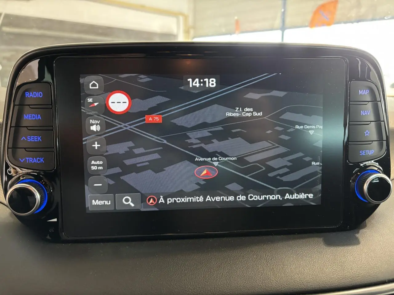 Écran tactile central du Hyundai Tucson 2020 affichant la navigation, boutons latéraux rétroéclairés en bleu.