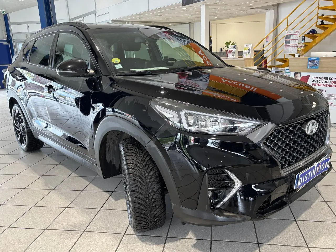 Hyundai Tucson noir en 3/4 avant droit, avec calandre N Line et jantes alliage noires 19 pouces.