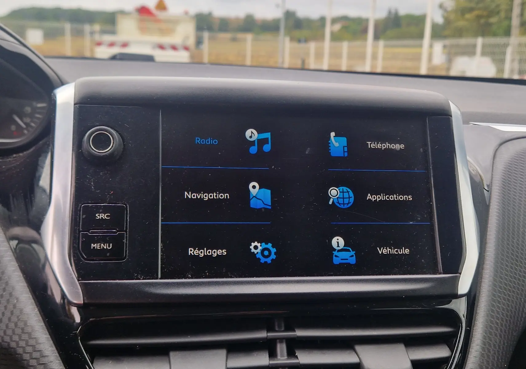 Écran tactile central de la Peugeot 208 blanc nacré 2018 affichant les options radio, navigation et téléphone.