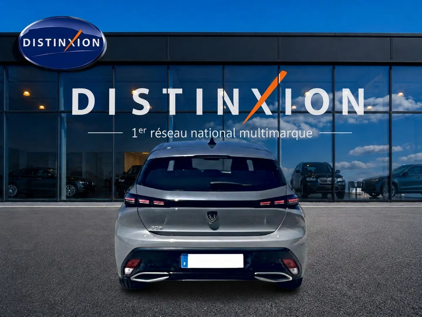 Vue arrière d'une Peugeot 308 gris métallisé 2025, avec feux arrière LED et double sortie d'échappement chromée.