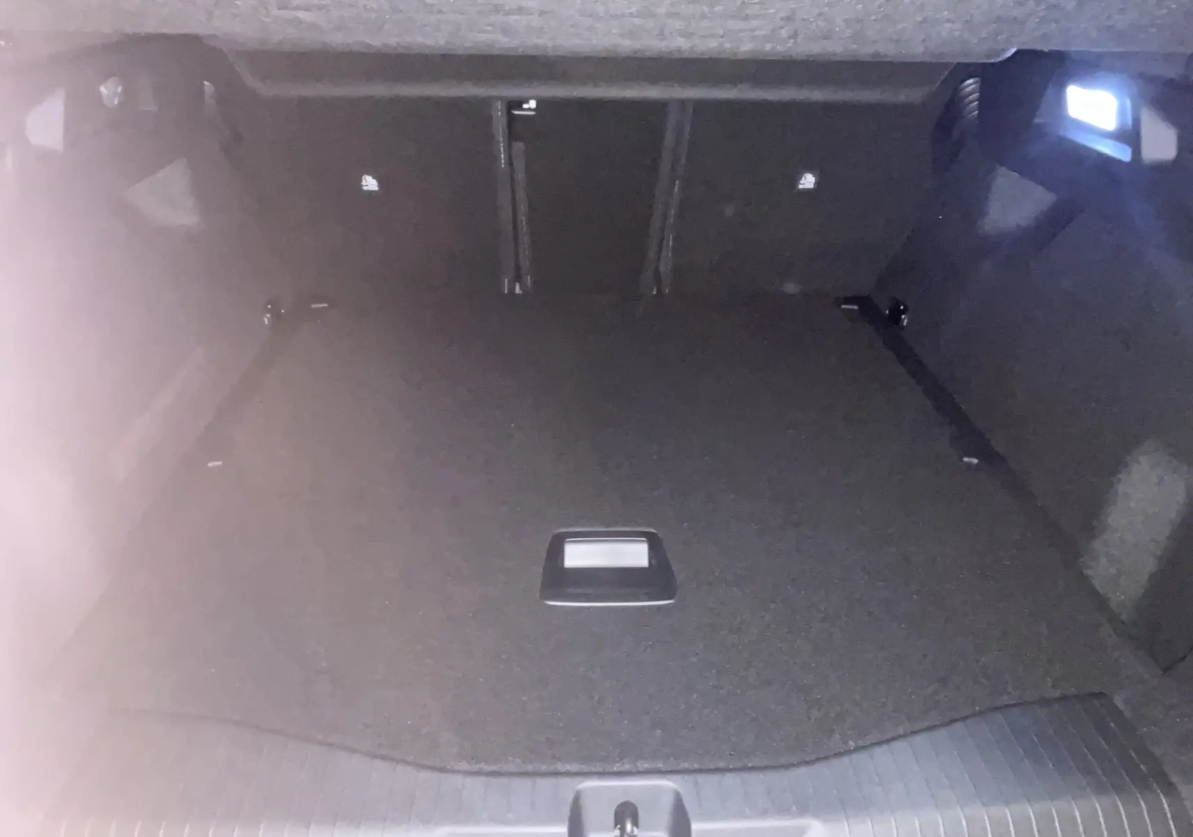 Vue 3/4 avant d'un Citroën C5 Aircross hybride 2026 gris platinium avec toit noir et phares allumés en intérieur.